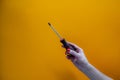 Hand of a young woman holding a screwdriverhand of a young woman holding a screwdriver, red nail polish on nails Royalty Free Stock Photo