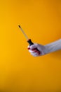 Hand of a young woman holding a screwdriverhand of a young woman holding a screwdriver, red nail polish on nails Royalty Free Stock Photo