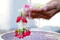 Hand of young woman pour water and flowers on the hands. older women and happy for the songkran festival. concept gives blessing