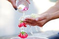 Hand of young woman pour water and flowers on the hands. older women and happy for the songkran festival. concept gives blessing