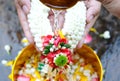 Hand of young woman pour water and flowers on the hands. older women and happy for the songkran festival. concept gives blessing