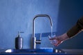 The hand of a young woman pours clean water