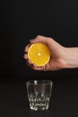 Hand of a young woman squeezes juice from an orange into a glass Royalty Free Stock Photo
