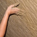 Hand of a young woman who builds an ecological wall with clay and straw plaster. Building with natural material