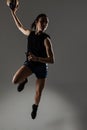 Handball player posing on gray background. Girl jumping with ball Royalty Free Stock Photo