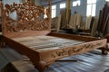handcarved wooden bed frame with detailed headboard in a workshop