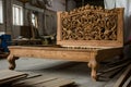 handcarved wooden bed frame with detailed headboard in a workshop