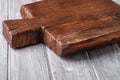 Handcraft dark brown teak wooden old cutting board, grey background Royalty Free Stock Photo