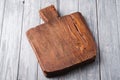 Handcraft dark brown teak wooden old cutting board, grey background Royalty Free Stock Photo