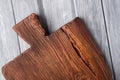 Handcraft dark brown teak wooden old cutting board, grey background Royalty Free Stock Photo