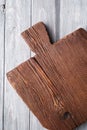 Handcraft dark brown teak wooden old cutting board, grey background Royalty Free Stock Photo