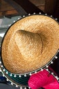 Handcrafted artisan Mexican straw woven sombrero hats hanging at local market on wooden plank. Cinco de Mayo Fifth of May
