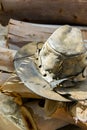 Handcrafted artisan old leather hat lying on wood logs in forest prepared for making fire.. Hiking camping wanderlust