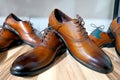 Handcrafted brown leather men shoes on the display shelves in the shoe shop.