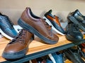 Handcrafted brown leather men shoes on the display shelves in the shoe shop.
