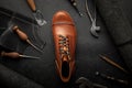 Handcrafted brown leather shoe with cobbler tools