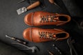 Handcrafted brown leather shoes with cobbler tools