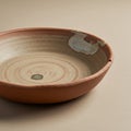 A handcrafted ceramic bowl displayed on a neutral surface. The bowl features an Royalty Free Stock Photo