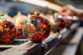 Handcrafted Christmas ornaments being painted with intricate designs in a workshop. Royalty Free Stock Photo