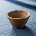 Handcrafted clay bowl with a rough textured surface is placed on a Royalty Free Stock Photo