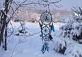 Handcrafted dream catcher with owl decoration and copy space against snow lanscape.