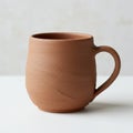 A handcrafted earthenware mug with a simple, smooth texture and natural terracotta Royalty Free Stock Photo
