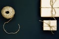 Handcrafted gift box wrapped in Craft paper with red wooden heart, rope and bow on black background. Top view, flat lay Royalty Free Stock Photo