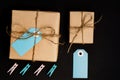 Handcrafted gift boxes wrapped in Craft paper  with blue paper card tag, rope and wooden  clothespins for decoration Royalty Free Stock Photo