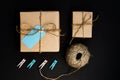 Handcrafted gift boxes wrapped in Craft paper  with blue paper card tag, rope and wooden  clothespins for decoration Royalty Free Stock Photo