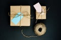 Handcrafted gift boxes wrapped in Craft paper with blue and pink paper card tag, rope and wooden clothespins for decoration Royalty Free Stock Photo