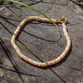 Handcrafted mother of pearl necklace from polished pieces on natural wooden background