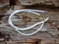 Handcrafted mother of pearl necklaces from polished pieces on natural wooden background