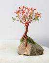 Handcrafted and painted wire tree for fall  attached to rock Royalty Free Stock Photo