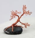 Handcrafted and painted wire tree attached to rock Royalty Free Stock Photo