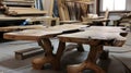 A handcrafted wooden table made from natural wood with unique grain patterns. The workshop background features various wood pieces Royalty Free Stock Photo