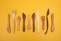 Handcrafted wooden utensils on yellow background Royalty Free Stock Photo