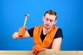 Handcrafting concept. Man, labourer, handyman in bright vest and protective gloves handcrafting, blue background