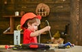 Handcrafting and workshop concept. Child in helmet cute playing as builder or repairer, or handcrafting. Toddler on busy