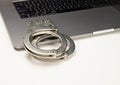 Handcuff closeup on laptop with banner copy space Royalty Free Stock Photo