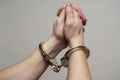 Handcuff on mans arms, praying for forgiveness. Chained hands praying. Praying inmate