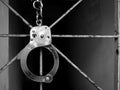 Handcuff shackle on steel cage in front of the dark way Royalty Free Stock Photo