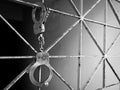 Handcuff shackle on steel cage in front of the dark way Royalty Free Stock Photo