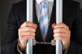 Handcuffed businessman holding bars Royalty Free Stock Photo