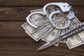 Handcuffed knife and money dollars.