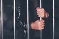 Handcuffed man behind prison bars Royalty Free Stock Photo