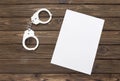 Handcuffs. A blank piece of paper against the background Royalty Free Stock Photo