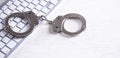 Handcuffs on computer keyboard. Concept of Cyber crime and Online fraud Royalty Free Stock Photo