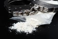 Handcuffs with drugs in a bag on a black background close-up. Law. A crime Royalty Free Stock Photo