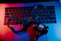 Handcuffs and gavel on a laptop in neon light. Cyber crime, online piracy and internet web hacking concept Royalty Free Stock Photo