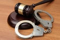 Handcuffs and gavel on a wood surface Royalty Free Stock Photo